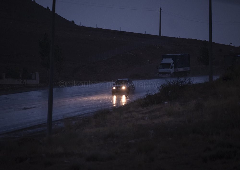 NPNW01JUL3122. In heavy rainstorm, a vehicle drives along a road near the flooded village of Mazdaran in Firoozkooh county 124 km (77 miles) northeast of Tehran, July 31, 2022.