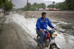 NPNW05AUG0122. A villager rides motorcycle along a road covered with mud during a sudden heavy rain in the flooded village of Mazdaran in Firoozkooh county 124 km (77 miles) northeast of Tehran, August 1, 2022.