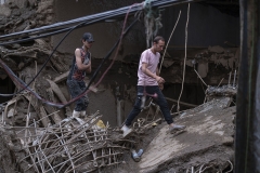 NPNW10JUL2922. Two Iranian men walk on ruins of a bridge and buildings which are demolished in flash flooding in the flooded village of Imamzadeh Davood in the northwestern part of Tehran on July 29, 2022.
