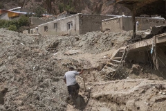 NPNW20JUL3122. A man walks on the ruins of residential buildings which are destroyed and covered with mud in the flooded village of Mazdaran in Firoozkooh county 124 km (77 miles) northeast of Tehran, after flash flooding, July 31, 2022.