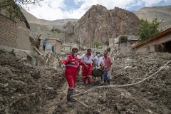 NPNW31JUL3122. Members of the Iranian Red Crescent Society (IRCC) and villagers carrying a body found from the ruins of a destroyed house in the flooded village of Mazdaran in Firoozkooh county 124 km (77 miles) northeast of Tehran, after flash flooding, July 31, 2022.